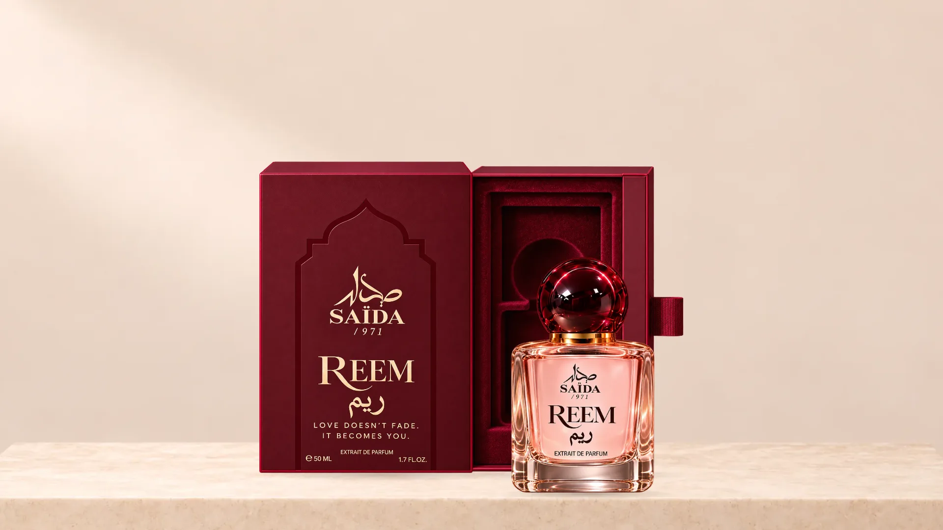 The Reem bottle standing beside its open box on a pale stone plinth.